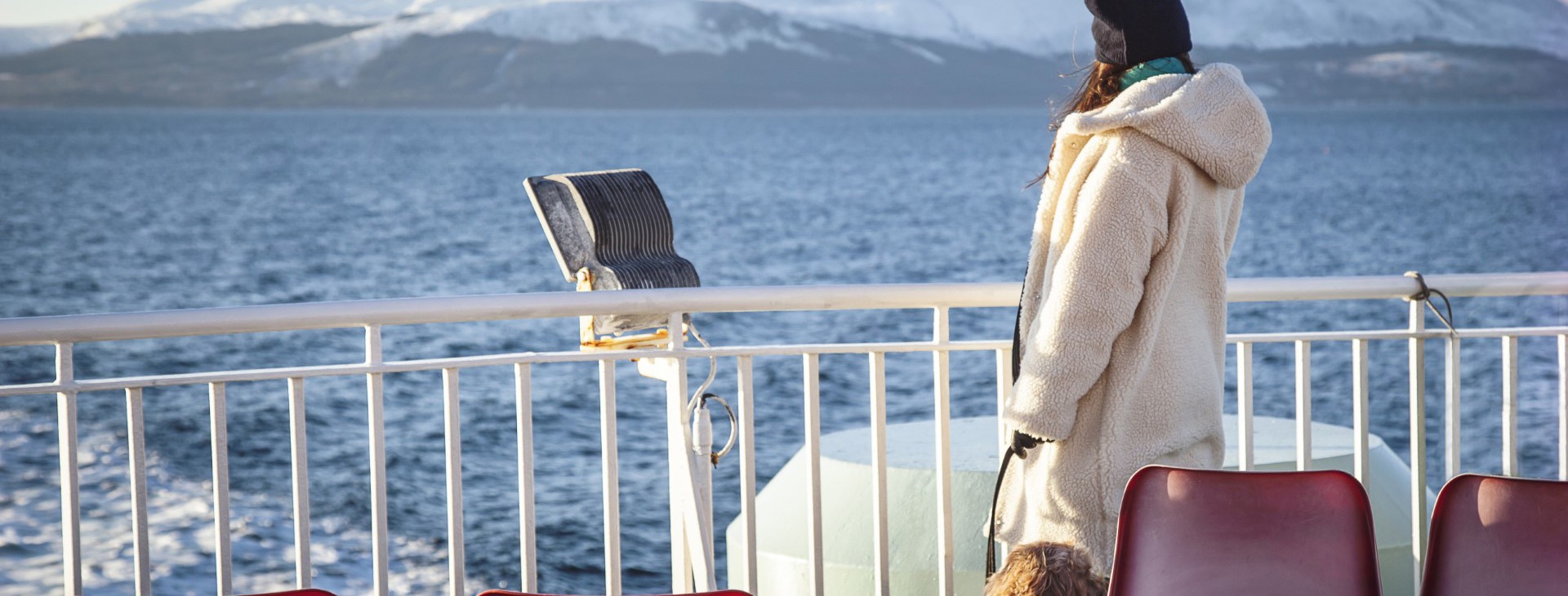 lady and her dog looking out from the deck of the boat