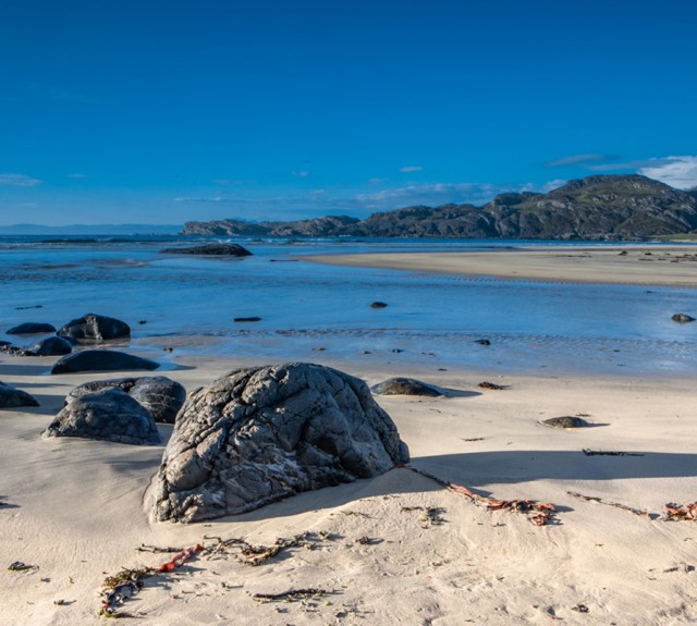 sandy beach with large rocks on the sand