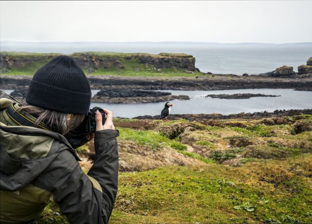 Photographer on Iona with puffin in background