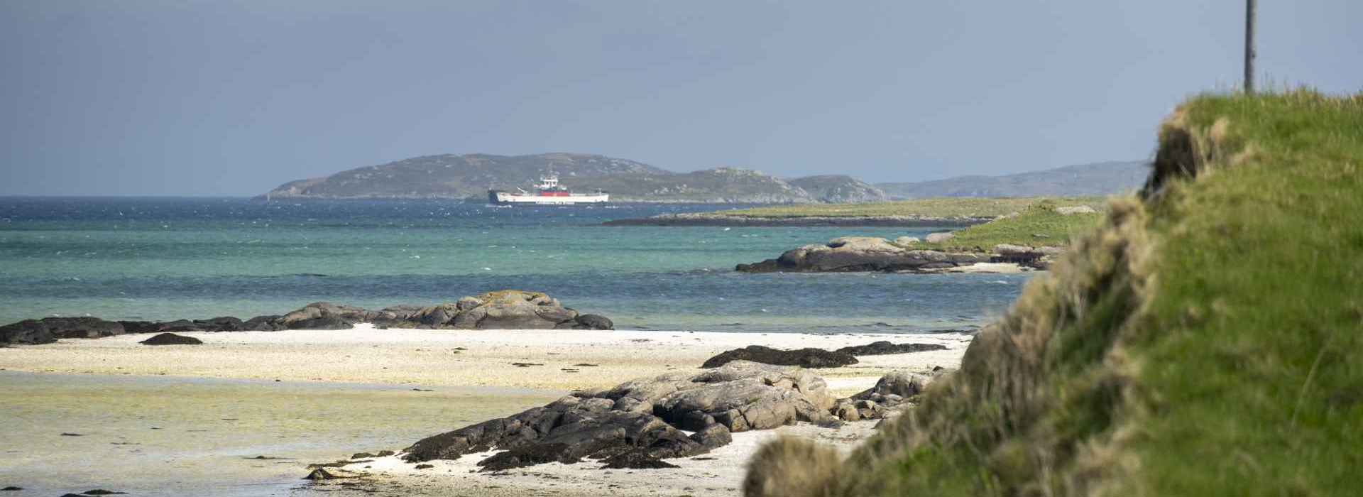 Barra beach view, with the CalMac ferry to Eriskay in the background