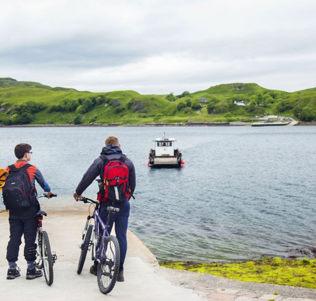 Two cyclists waiting to travel to the isle of Kerrera on the ferry  and explore the Hutcheson monument