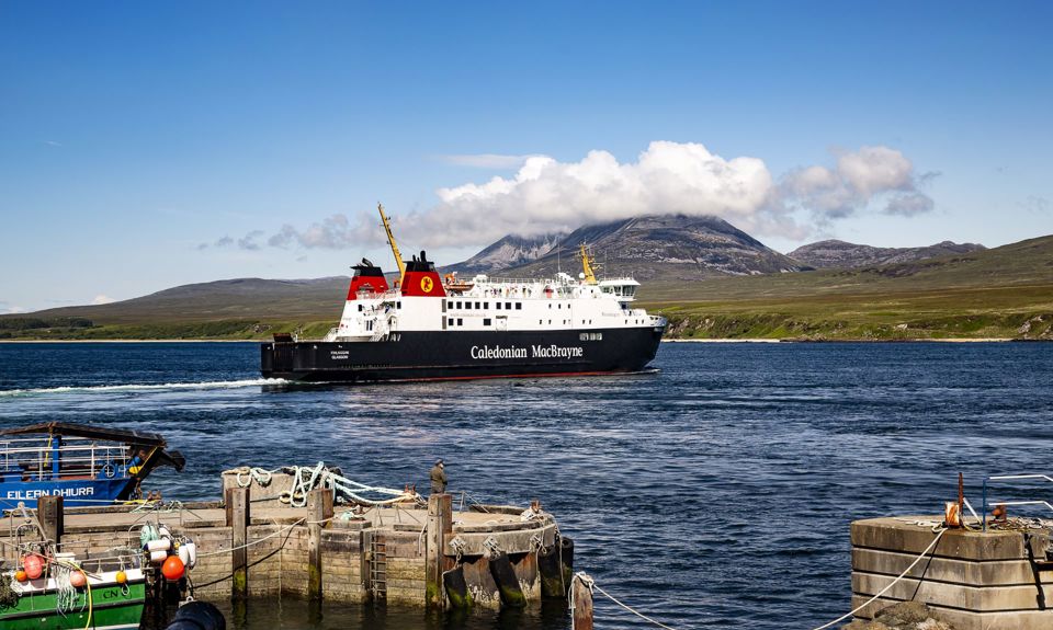 The MV Finlaggan leaving harbour with the cloud covered Paps of Jura in the backgound