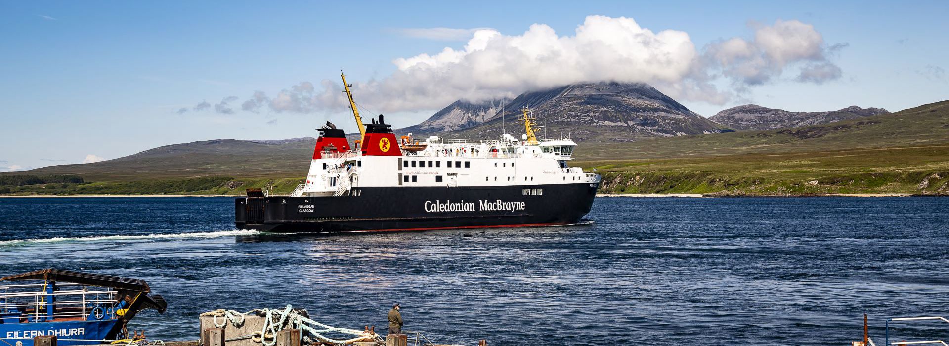 The MV Finlaggan leaving harbour with the cloud covered Paps of Jura in the backgound